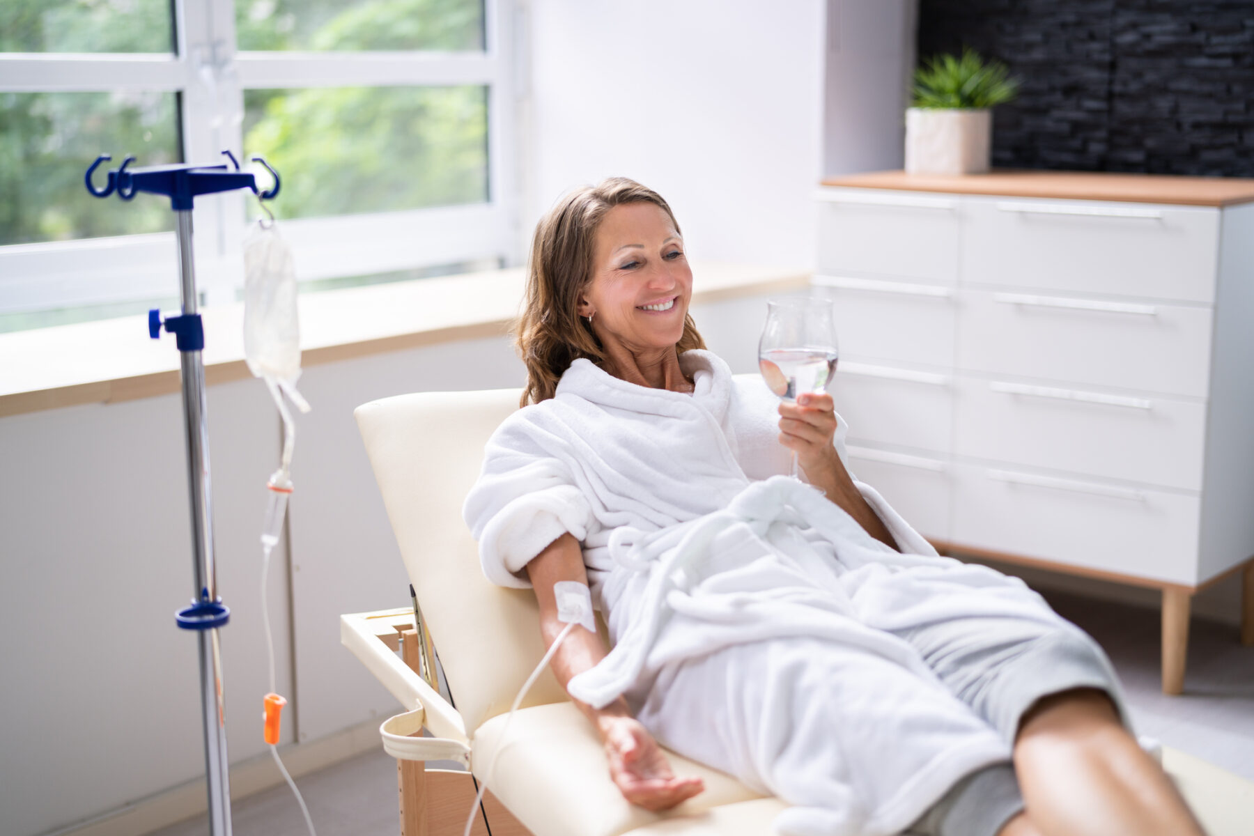 Smiling woman receiving vitamin IV