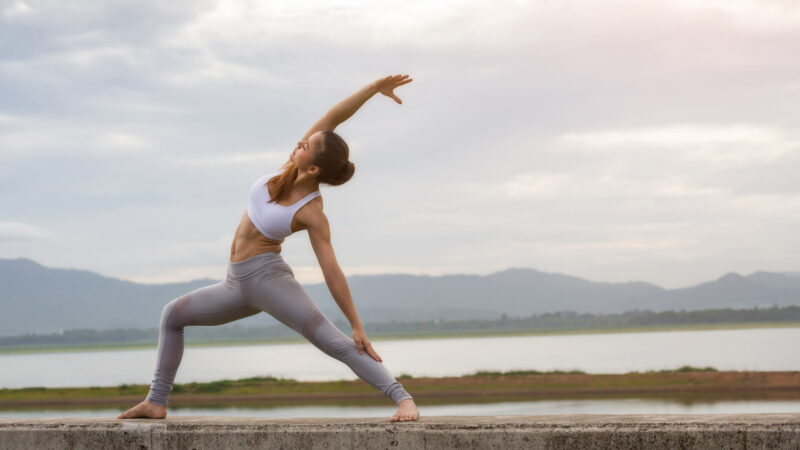 a woman doing yoga against a backdrop of water