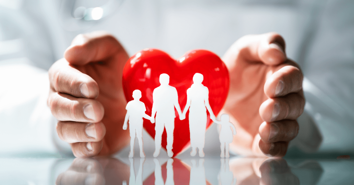 a person holding a red heart with a cutout of a family