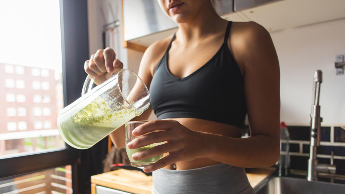 a woman drinking infused water as part of a detox program