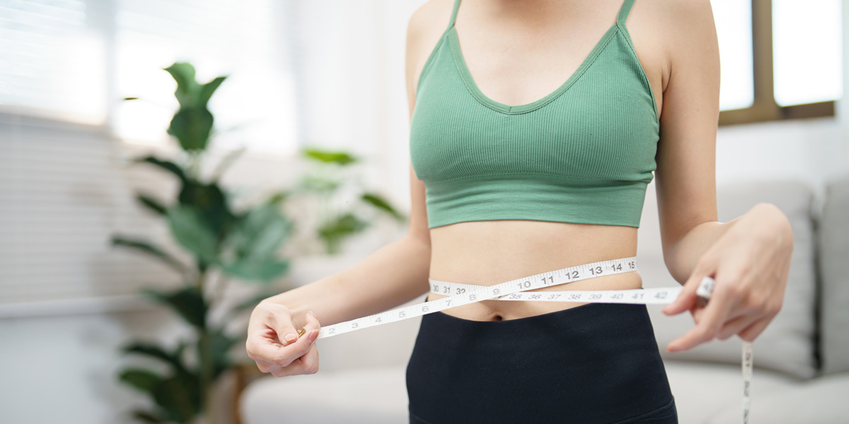 a woman holding a tape measure around her waist